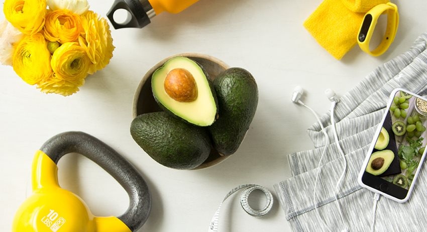 Bowl of avocados surrounded by healthy lifestyle items
